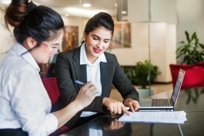 Indian female agent helping client sign the application document